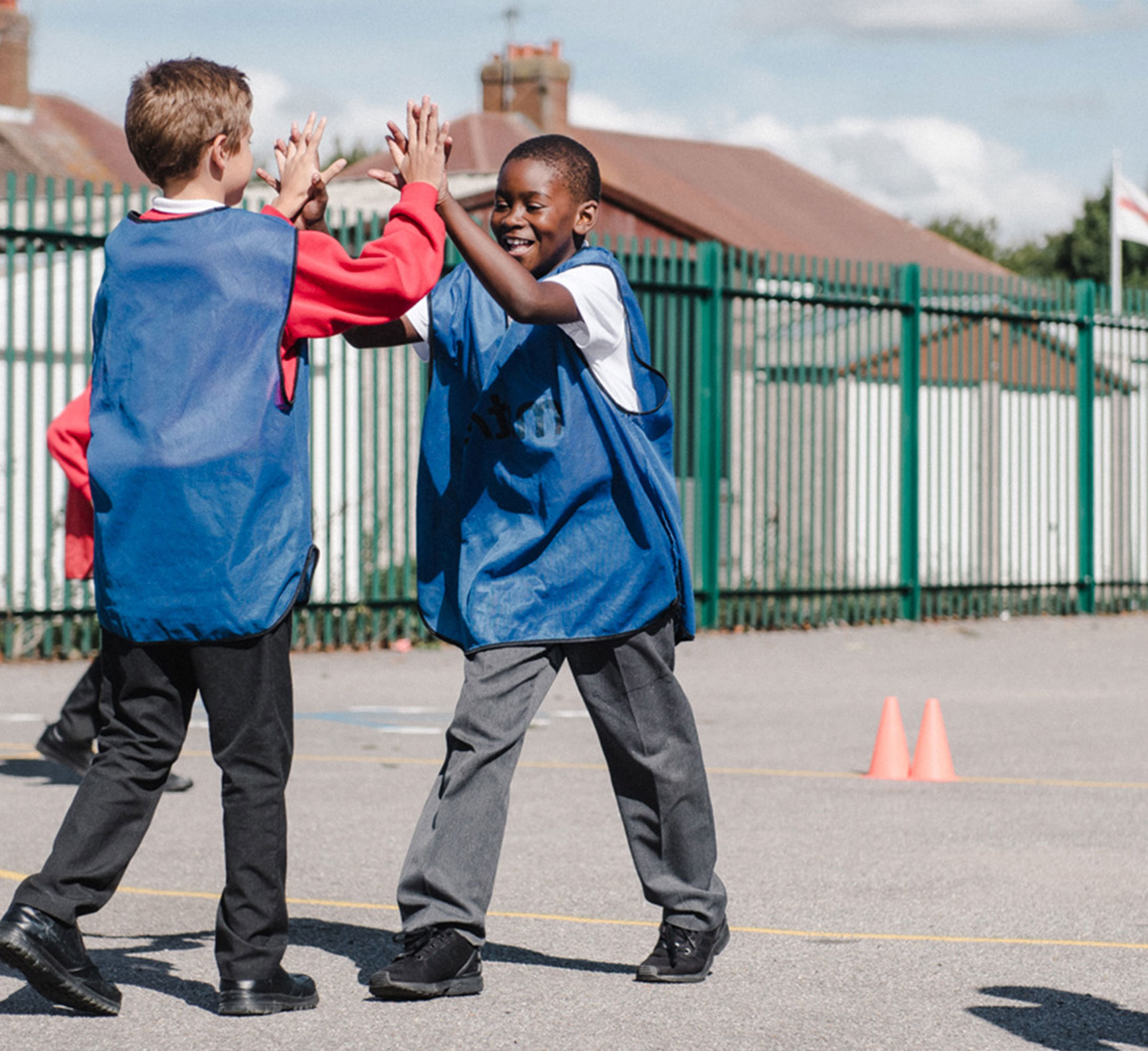 Two boys high five in the playground
